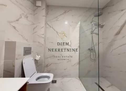 Modernly equipped bathroom with a walk-in shower and marble tiles. - image 17