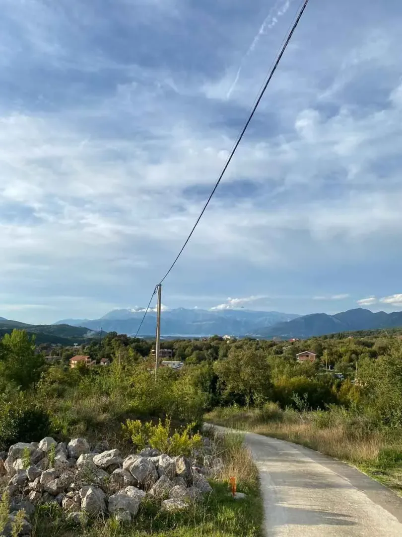 Pogled na okolni krajolik, brda i put koji vodi do lokacije.