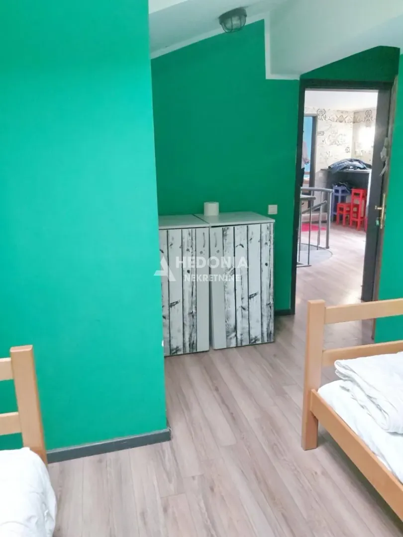 Spavaća soba sa zelenim zidovima i drvenim krevetima.