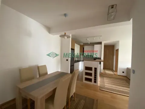 Dining area with a wooden table and chairs overlooking the kitchen. - image 14