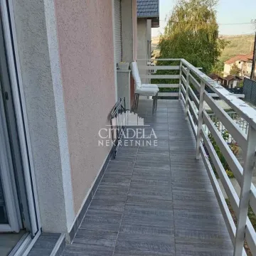 Prostrana natkrivena terasa sa keramičkim pločicama i metalnom ogradom. - image 15