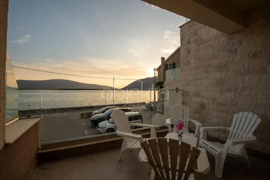 Covered terrace with outdoor seating and a sea view.