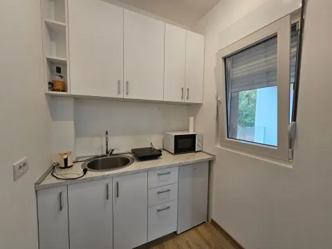 Small white kitchen with a sink, countertop, and window. - image 8