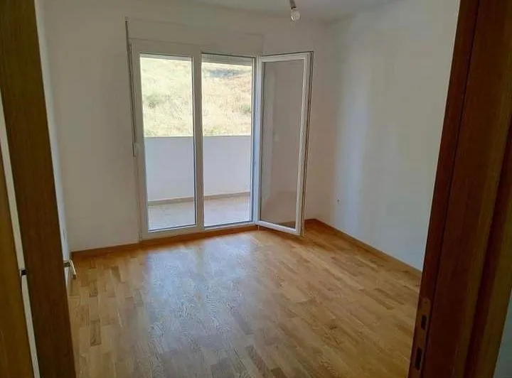 Empty room with parquet flooring and access to the terrace.