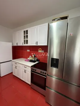 Kitchen with white cabinetry, red tiles, and a stove. - image 17