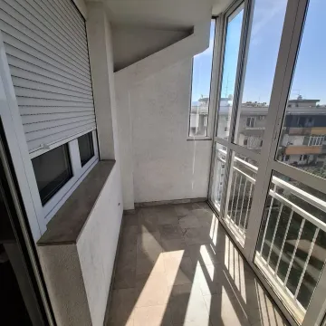 Zastakljeni balkon sa keramičkim podom i pogledom na okolne zgrade. - image 8