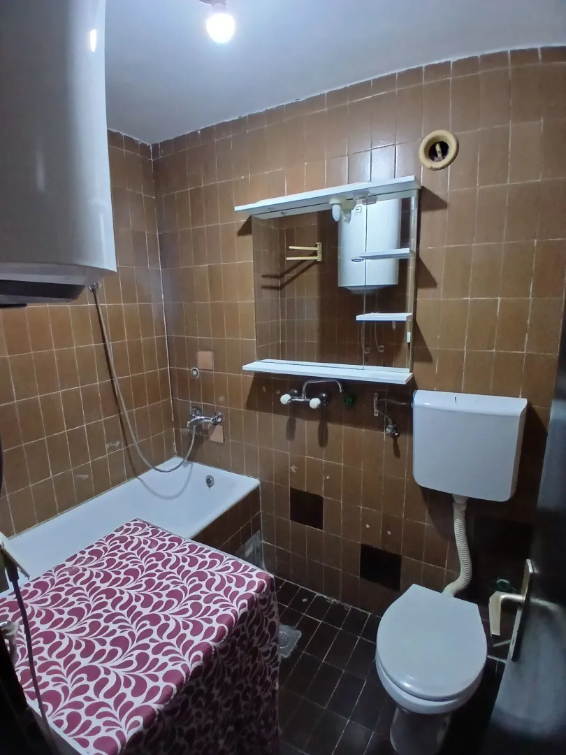 Kupatilo sa kadom, wc šoljom i ogledalom sa policama.