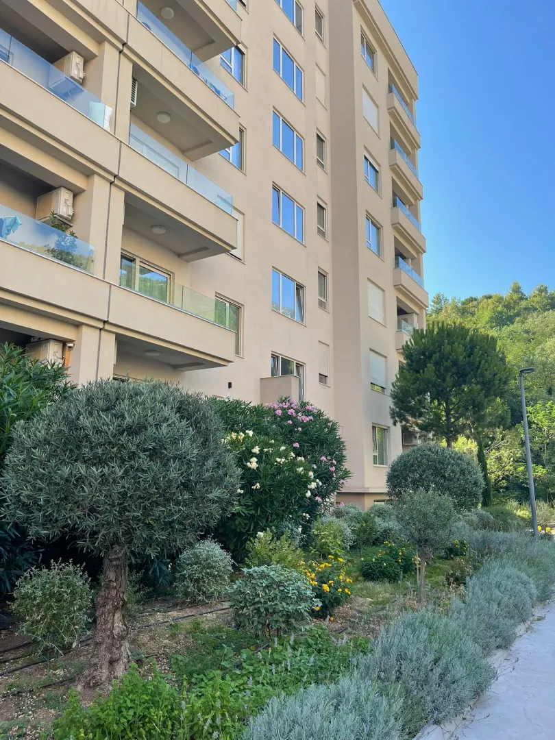 Exterior of the residential building with landscaped courtyard and greenery.