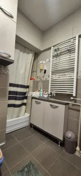 Smaller bathroom with a shower cabin, cabinet, and towel radiator. - image 7
