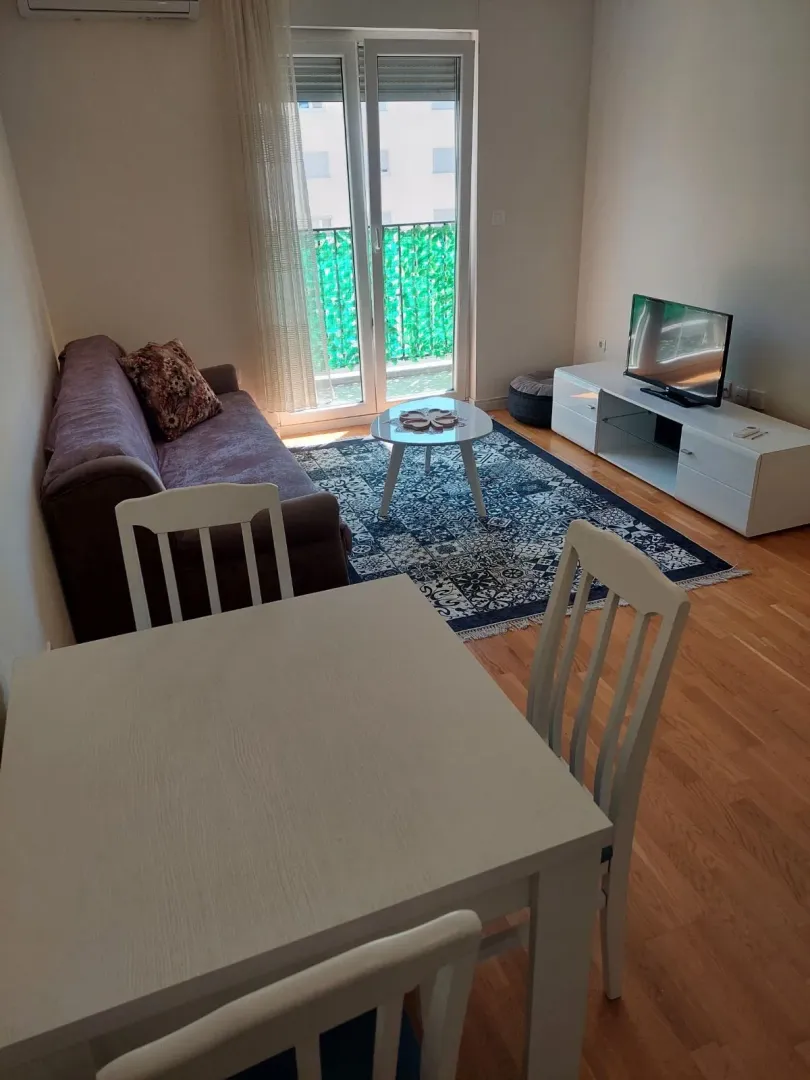 Dnevni boravak sa garniturom, trpezarijskim stolom i izlazom na terasu.