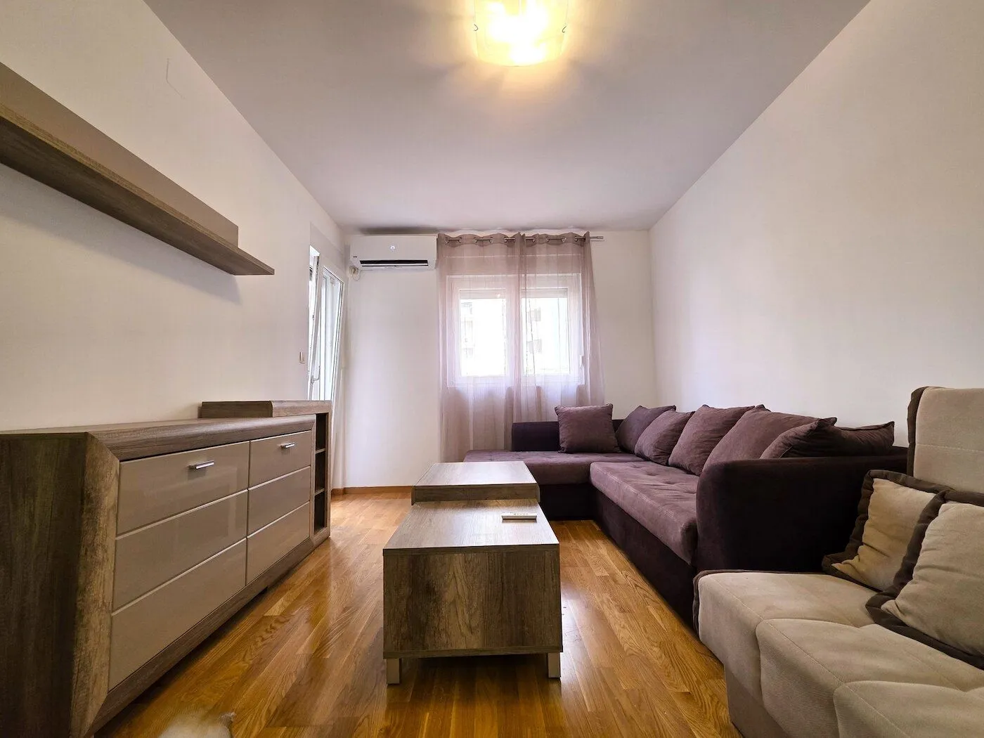 Living room with a sofa set, wooden coffee tables, and a dresser.