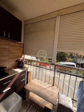 Enclosed balcony with a small table and built-in units. - image 5
