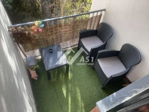 Manji namešten balkon sa garniturom za sedenje i veštačkom travom. - image 2