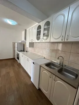 View of a bright kitchen with white cabinets and a sink. - image 6