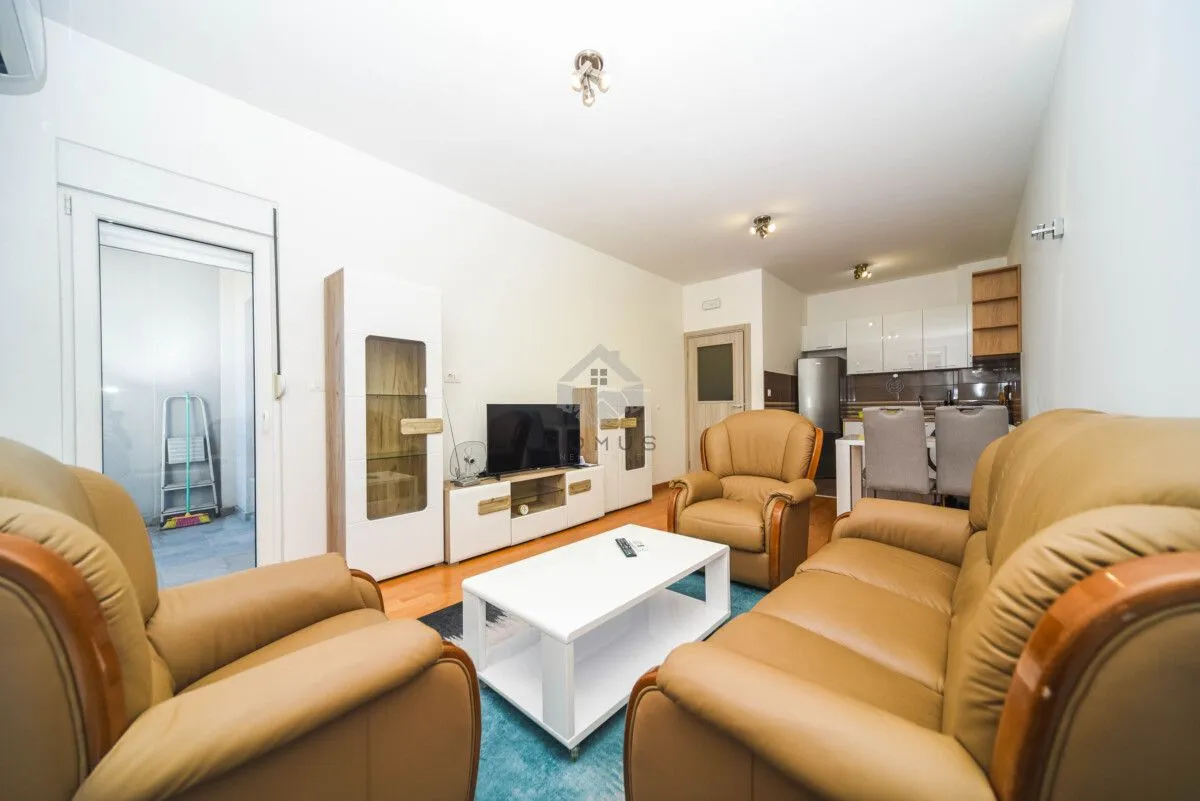 Living room with leather furniture sets, a white coffee table, and a TV unit.