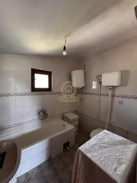 Older furnished bathroom with a bathtub, toilet, and water heater. - image 17