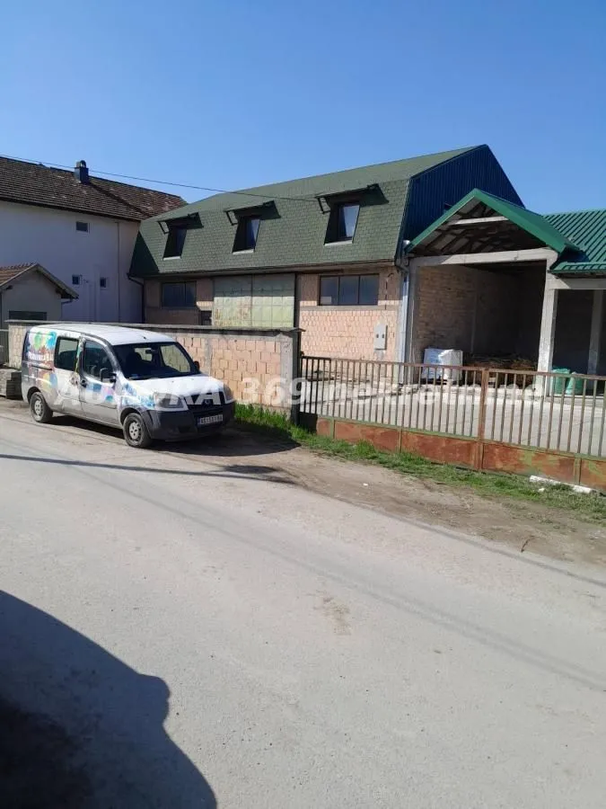 Exterior view of the house with a yard and a parked van.