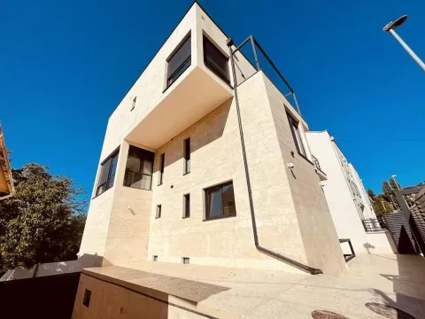 View of the exterior of a modern stone-clad multi-family building. - image 10
