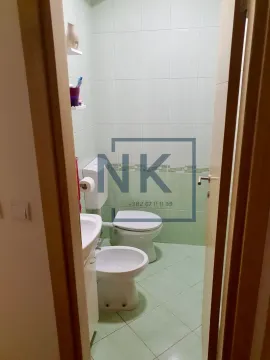 Smaller bathroom tiled in green with a toilet, bidet, and washbasin. - image 11