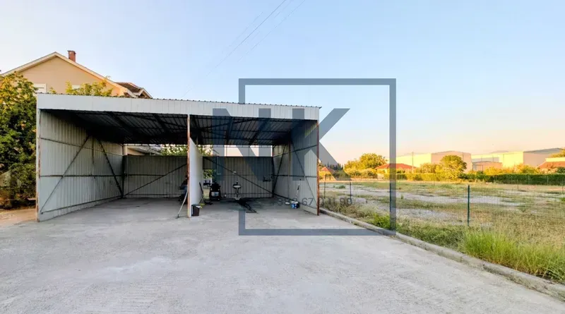 Natkriveni vanjski prostor sa metalnom konstrukcijom i betonskom podlogom u dvorištu.