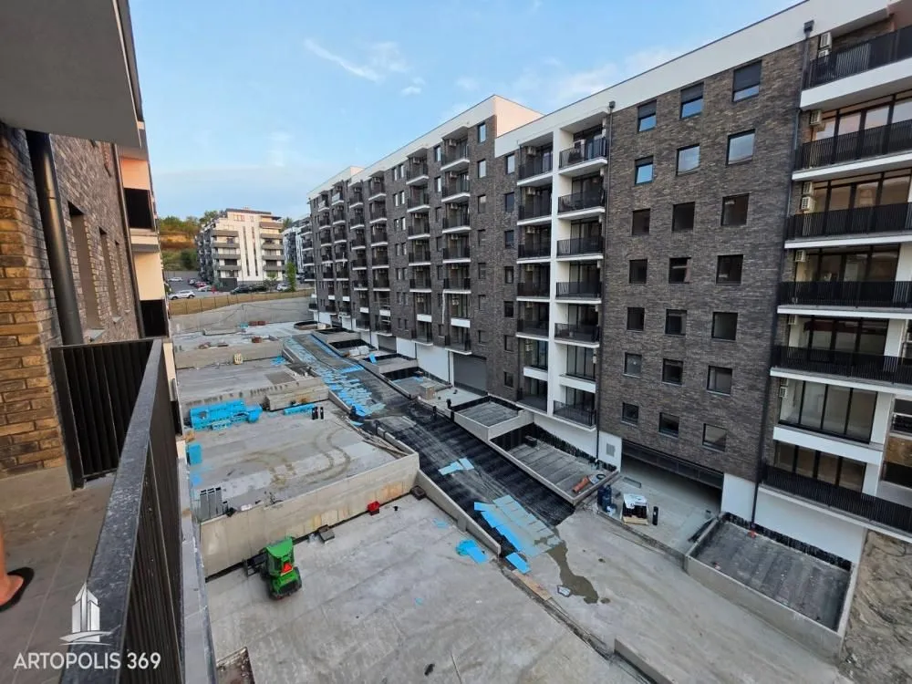 View from the balcony of the building exterior and surrounding area under construction.