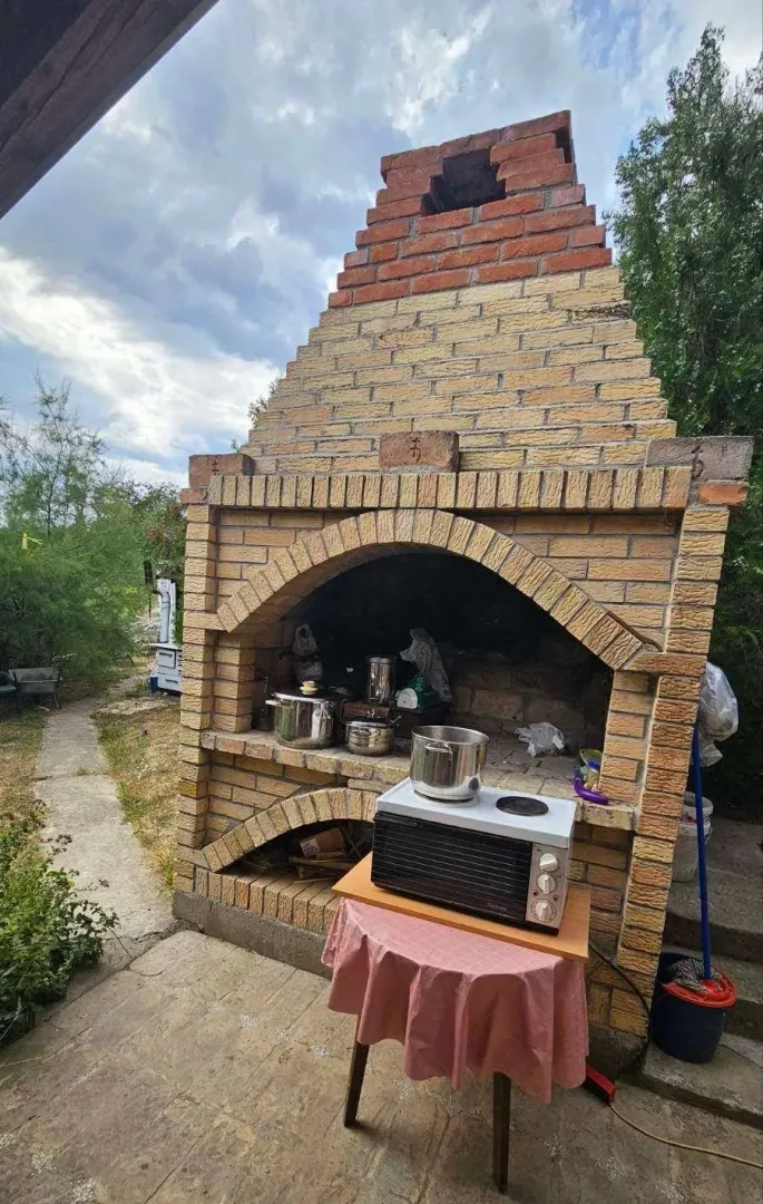 Veliki zidani roštilj u dvorištu kuće.