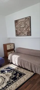 A room with a bed, nightstand, and a painting on the wall. - image 3
