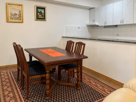 Trpezarija sa drvenim stolom i stolicama, povezana sa kuhinjom. - image 3