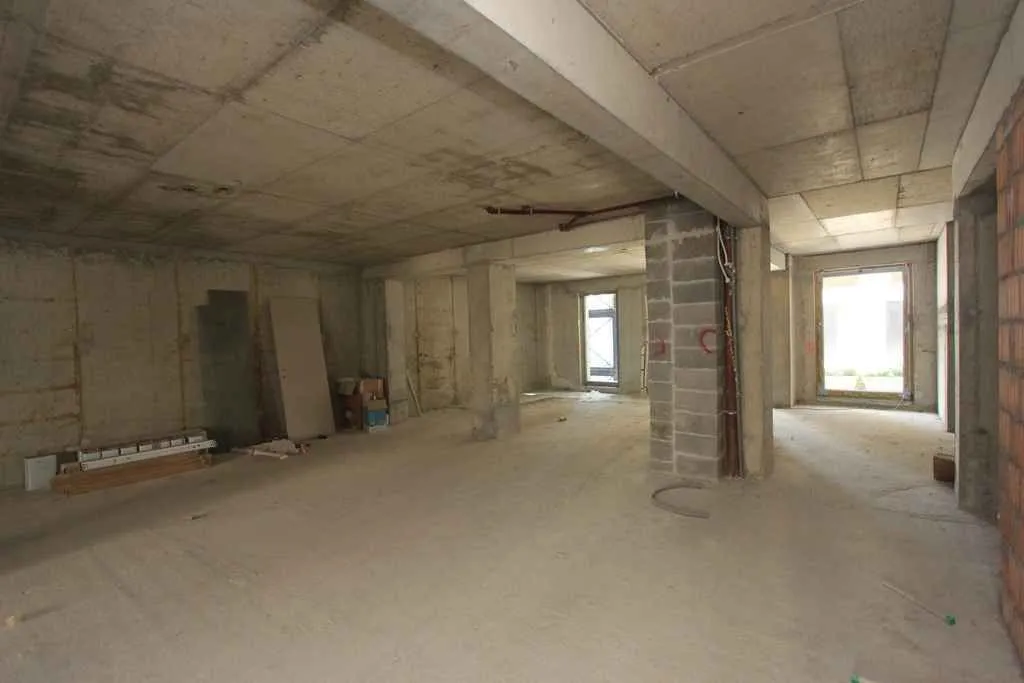 Interior of a spacious property under construction with concrete pillars.