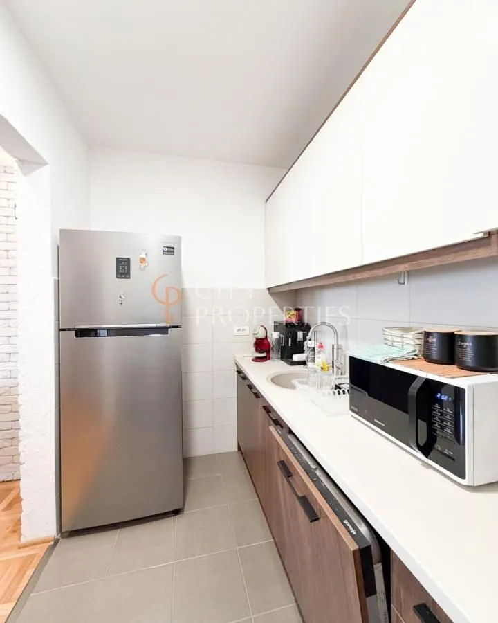 Kitchen with wooden cabinetry, refrigerator, and built-in appliances.