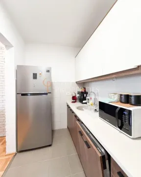 Kitchen with wooden cabinetry, refrigerator, and built-in appliances. - image 9