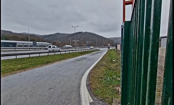 View of the access road and surroundings with the highway in the background.