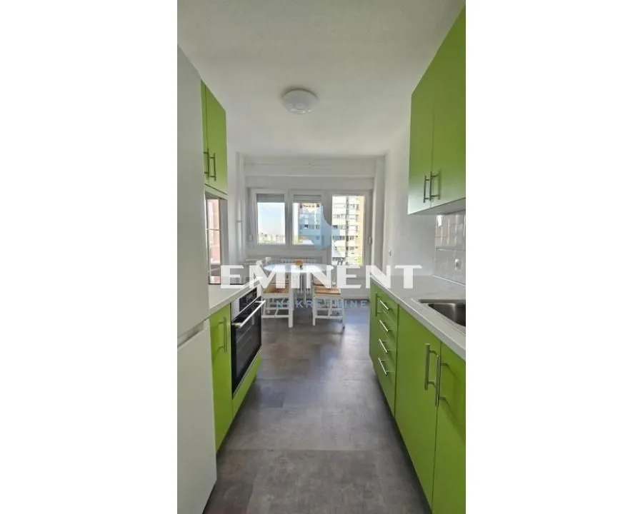 Small kitchen with green cabinets and a view of the dining area.