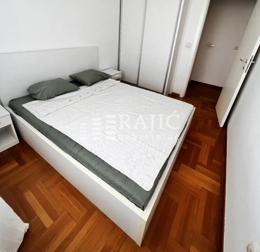 Furnished bedroom with a double bed and a built-in wardrobe.