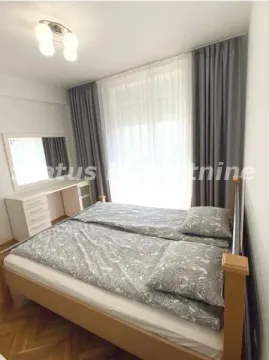 Nameštena spavaća soba sa bračnim krevetom, belom komodom i zavesama. - image 6