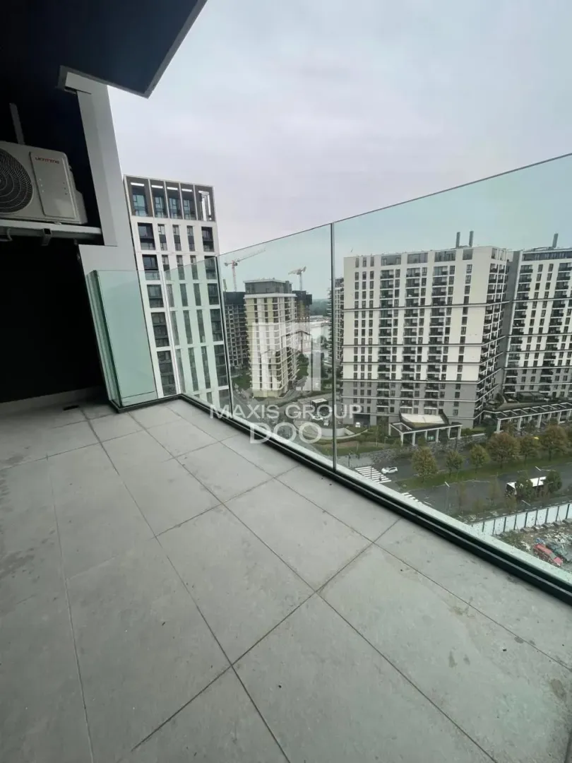 Balcony with a glass railing and a view of urban buildings.
