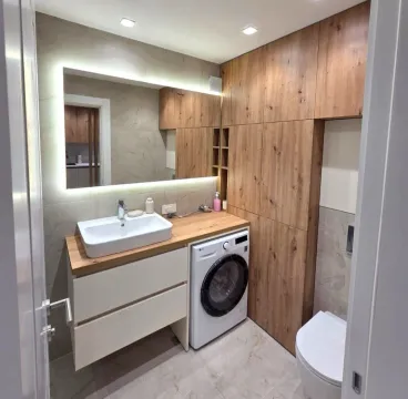 Modernly equipped bathroom with a washbasin, washing machine, and built-in units. - image 9