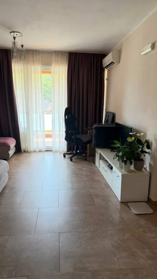 Living room with furniture, TV, and access to the terrace.
