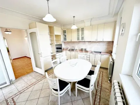 Spacious kitchen with a dining area and light-colored cabinetry. - image 16