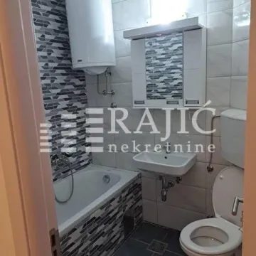 Smaller bathroom with a bathtub, washbasin, and toilet. - image 2