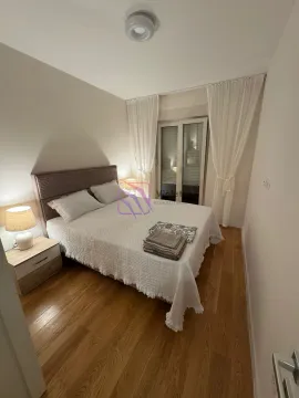 Namještena spavaća soba sa bračnim krevetom, noćnim stočićem i prozorom sa bijelim zavjesama. - image 3