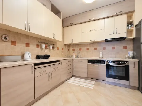 Equipped kitchen with wooden cabinetry and ceramic wall tiles. - image 10