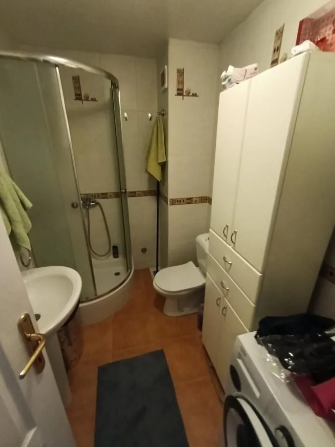 Kupatilo opremljeno tuš kabinom, umivaonikom, toaletom i veš mašinom.