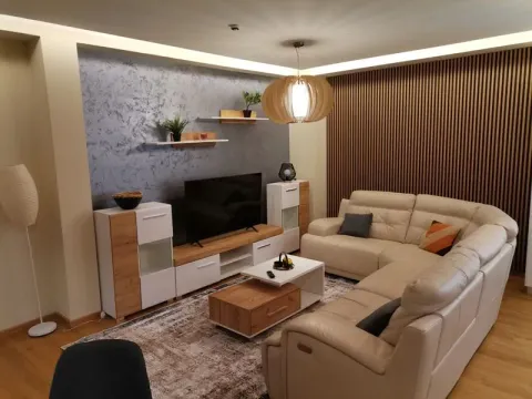 Living room with a sectional sofa, TV, and modern furniture. - image 3