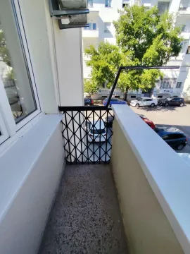 Manji balkon sa metalnom ogradom i pogledom na ulicu i parking. - image 13