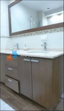 Bathroom with wooden vanity and a large wall mirror. - image 14