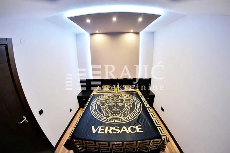 Modern bedroom with a double bed and a drop ceiling with lighting.
