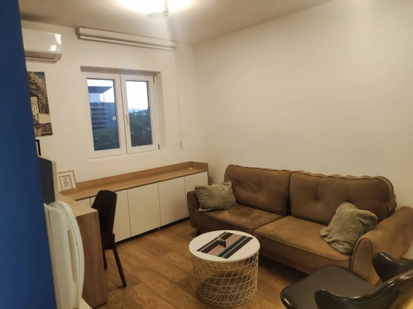 Living room with a brown sofa, coffee table and a window.