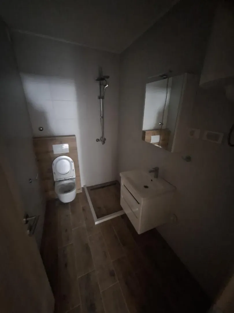 Kupatilo opremljeno tuš kabinom, umivaonikom i toaletom.