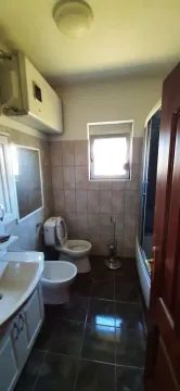 Bathroom equipped with sanitary ware, a shower cabin, and a water heater. - image 12